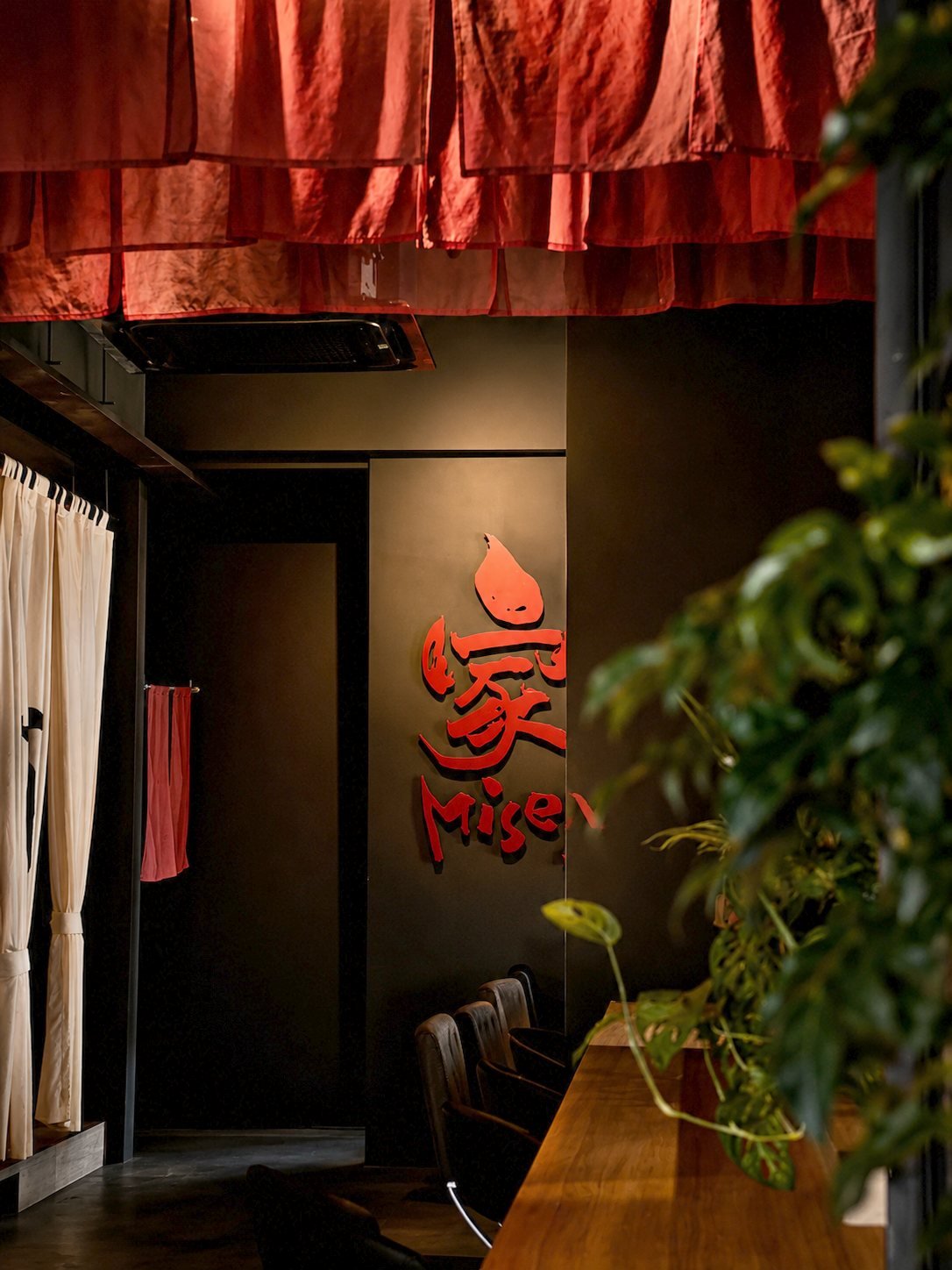 Red noren fabric draped above the Miseya calligraphy wall and counter